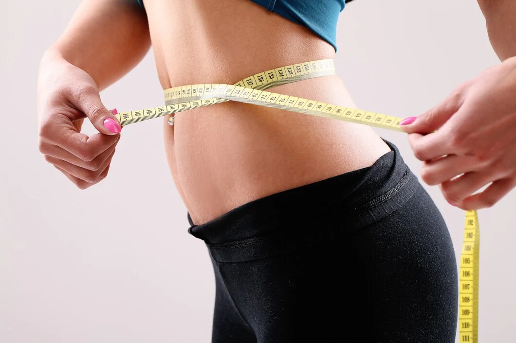 A girl holds a tape in her hands and wraps it around her waist. How to Lose Weight in 2024